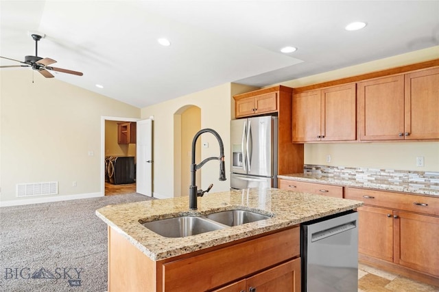 1705 Ingomar Blvd, Belgrade, MT 59714 - kitchen featuring appliances with stainless steel finishes, a center island with sink, a ceiling fan, recessed lighting, and arched walkways