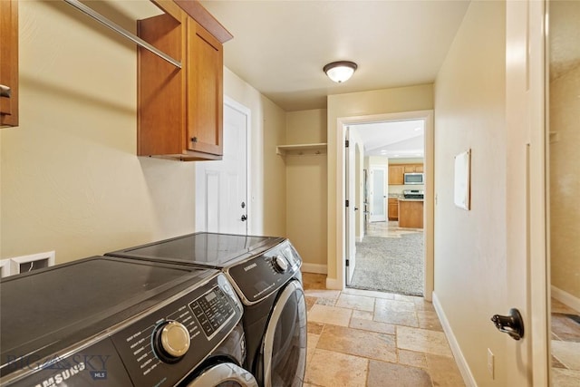 1705 Ingomar Blvd, Belgrade, MT 59714 - laundry room featuring washing machine and clothes dryer, stone tile flooring, and cabinet space