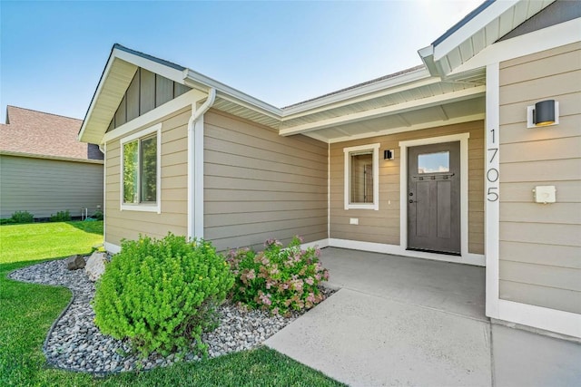 1705 Ingomar Blvd, Belgrade, MT 59714 - doorway to property with board and batten siding and a yard