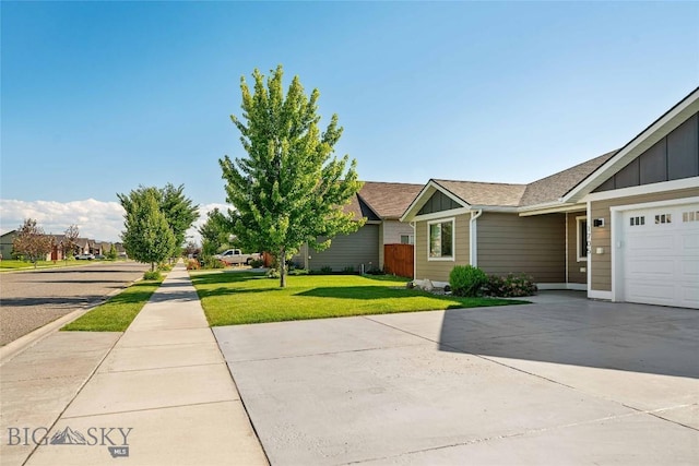 1705 Ingomar Blvd, Belgrade, MT 59714 - view of front of property featuring board and batten siding, driveway, a front yard, and an attached garage