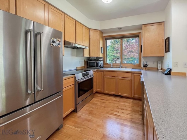 1031 Boylan, Bozeman, MT 59715 - kitchen featuring appliances with stainless steel finishes, under cabinet range hood, light wood-type flooring, light brown cabinetry, and light countertops