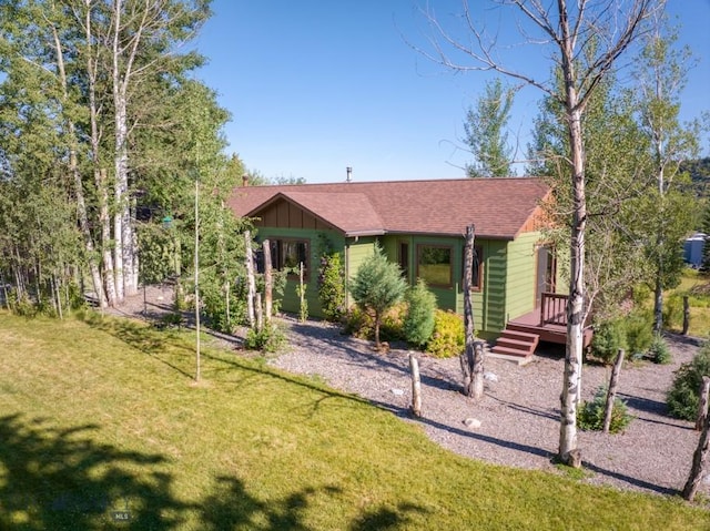 8799 Huffman Ln, Bozeman, MT 59715 - view of front of home with a front lawn, board and batten siding, a deck, and roof with shingles