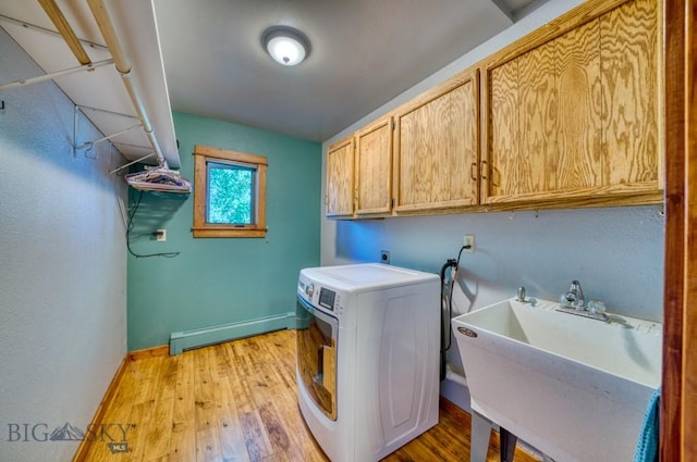 8799 Huffman Ln, Bozeman, MT 59715 - washroom featuring a baseboard heating unit, washer / clothes dryer, cabinet space, and light wood-style floors
