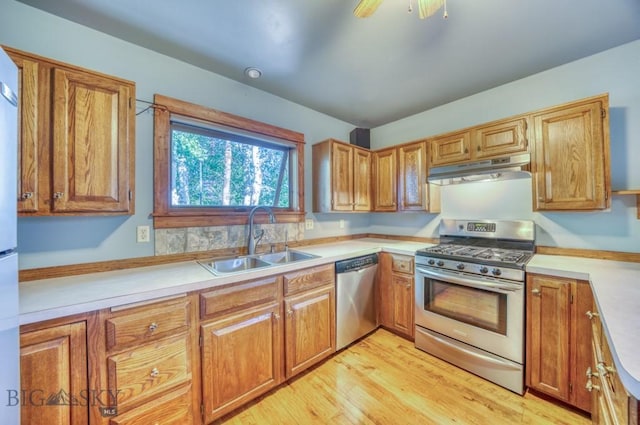 8799 Huffman Ln, Bozeman, MT 59715 - kitchen featuring stainless steel appliances, under cabinet range hood, light wood finished floors, and light countertops