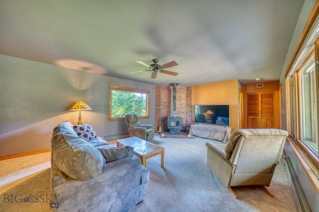 8799 Huffman Ln, Bozeman, MT 59715 - carpeted living area with a wood stove, baseboard heating, a ceiling fan, and a baseboard radiator