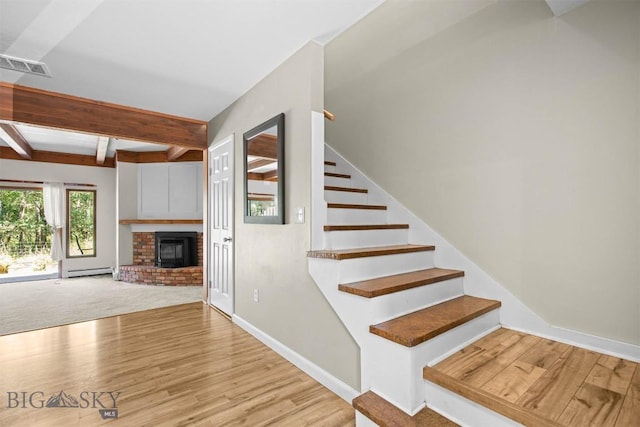 2020 S Rouse Unit 7, Bozeman, MT 59715 - stairway with beamed ceiling, a baseboard heating unit, wood finished floors, and a brick fireplace