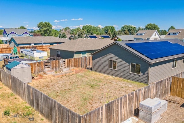 616 W Adams St, Three Forks, MT 59752 - back of property featuring a fenced backyard, a shed, solar panels, and a residential view