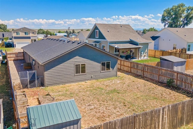 616 W Adams St, Three Forks, MT 59752 - back of house with a residential view, a shed, a fenced backyard, and a vegetable garden
