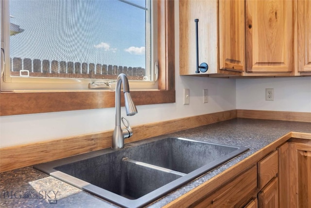 616 W Adams St, Three Forks, MT 59752 - kitchen with dark countertops and brown cabinetry