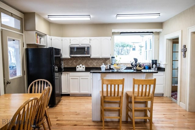 300 Holmes, Butte, MT 59701 - kitchen with stainless steel microwave, freestanding refrigerator, light wood finished floors, and dark countertops