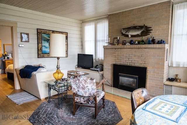 300 Holmes, Butte, MT 59701 - living room featuring light wood-type flooring, a brick fireplace, and wooden walls