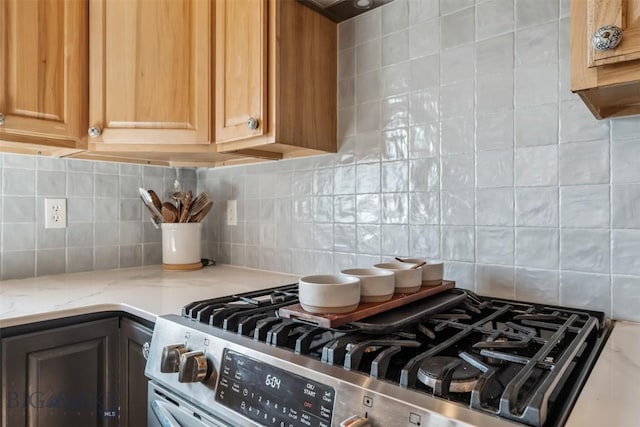 219 Rolling Glen Ranch Loop, Three Forks, MT 59752 - kitchen view of stainless steel gas range, tasteful backsplash, and light stone counters