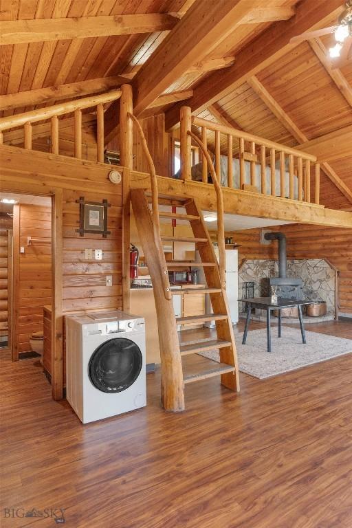 3500 Jackson Creek Rd, Bozeman, MT 59715 - unfurnished living room with washer / clothes dryer, a wood stove, wooden walls, a wooden ceiling with exposed beams, and stairs
