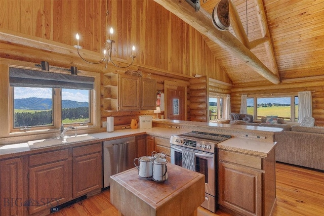 3500 Jackson Creek Rd, Bozeman, MT 59715 - kitchen featuring stainless steel appliances, log walls, open floor plan, a peninsula, and light countertops
