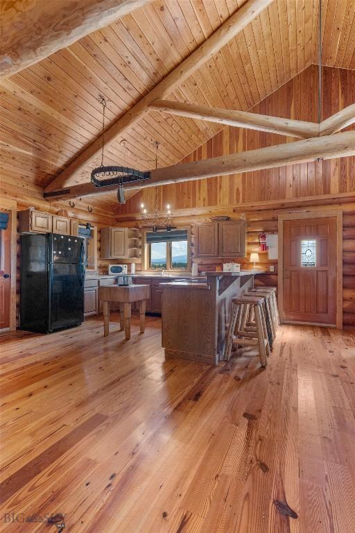 3500 Jackson Creek Rd, Bozeman, MT 59715 - kitchen featuring freestanding refrigerator, light wood-style flooring, a kitchen breakfast bar, a wooden ceiling with exposed beams, and a peninsula