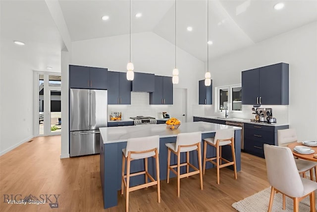 2809 S 30th Ave, Bozeman, MT 59718 - kitchen featuring stainless steel appliances, high vaulted ceiling, a breakfast bar area, blue cabinets, and light countertops