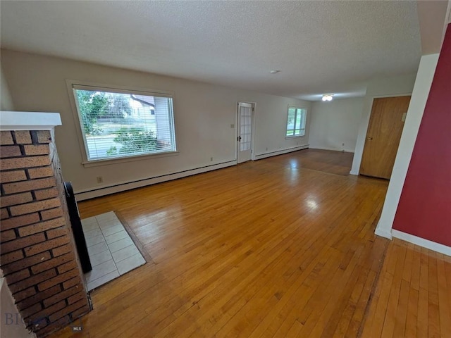 944 Placer, Butte, MT 59701 - unfurnished living room with a baseboard heating unit, wood-type flooring, and a textured ceiling