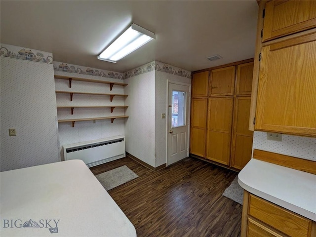 944 Placer, Butte, MT 59701 - kitchen with a baseboard radiator, wallpapered walls, dark wood-style floors, light countertops, and brown cabinetry