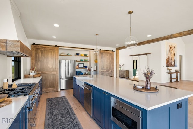 120 Horseshoe Loop, Harrison, MT 59735 - kitchen featuring a barn door, blue cabinetry, stainless steel appliances, custom exhaust hood, and recessed lighting