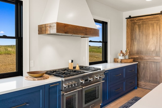 120 Horseshoe Loop, Harrison, MT 59735 - kitchen featuring premium range hood, range with two ovens, blue cabinets, light wood finished floors, and light countertops