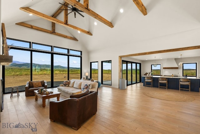 120 Horseshoe Loop, Harrison, MT 59735 - living room with high vaulted ceiling, beamed ceiling, light wood-style flooring, a mountain view, and recessed lighting