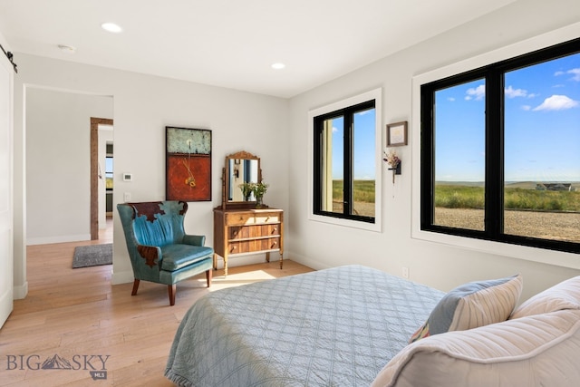 120 Horseshoe Loop, Harrison, MT 59735 - bedroom with light wood-style flooring, recessed lighting, and a barn door