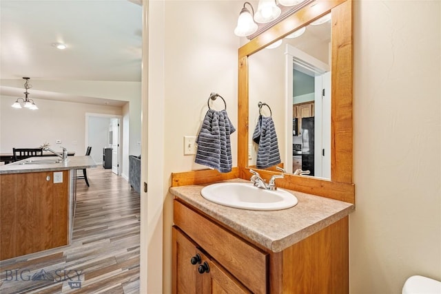 160 Tail Feather Ln Unit D, Bozeman, MT 59718 - half bathroom featuring vanity, wood finished floors, and a chandelier