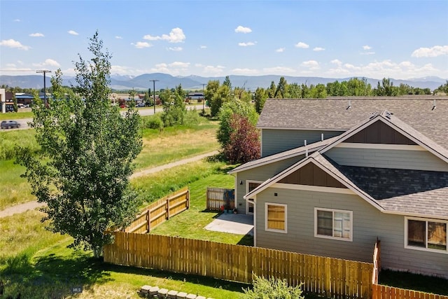 160 Tail Feather Ln Unit D, Bozeman, MT 59718 - rear view of property with a mountain view, a shingled roof, and board and batten siding