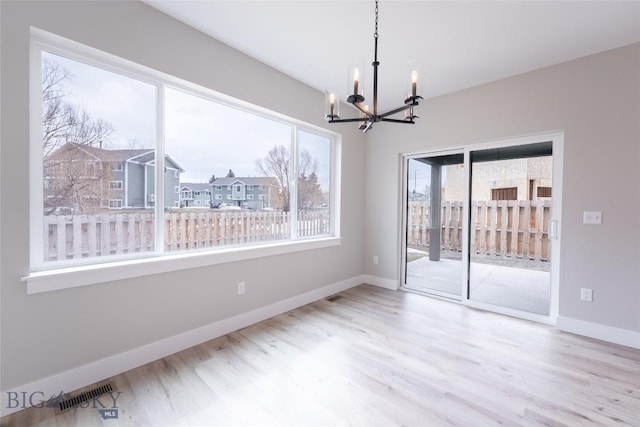 740 Rogers Way Unit B, Bozeman, MT 59718 - empty room with a chandelier, healthy amount of natural light, and wood finished floors