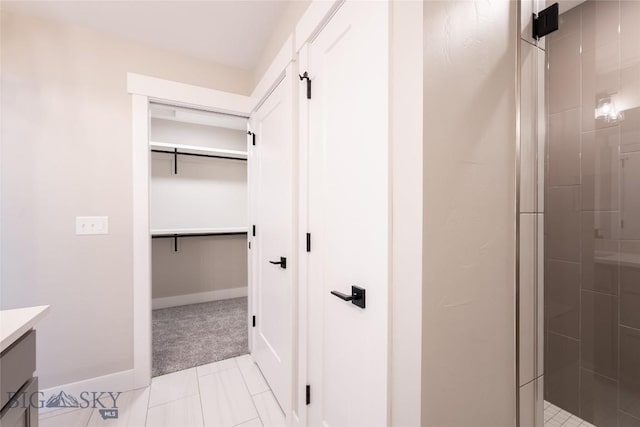 740 Rogers Way Unit B, Bozeman, MT 59718 - full bath featuring vanity, tiled shower, a spacious closet, and tile patterned floors