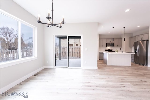 740 Rogers Way Unit B, Bozeman, MT 59718 - kitchen with stainless steel appliances, gray cabinetry, plenty of natural light, a chandelier, and recessed lighting