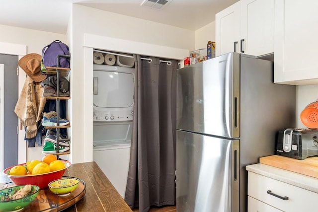2 Harris Pl, Livingston, MT 59047 - kitchen with estacked washer and dryer, freestanding refrigerator, and white cabinetry