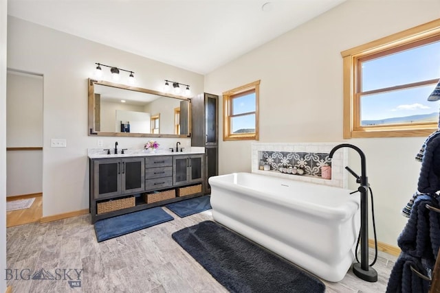 915 Point Of Rocks Rd, Whitehall, MT 59759 - full bath featuring double vanity, a freestanding bath, and wood finished floors