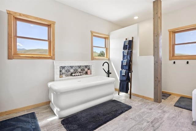 915 Point Of Rocks Rd, Whitehall, MT 59759 - bathroom with a freestanding tub, wood finished floors, and plenty of natural light