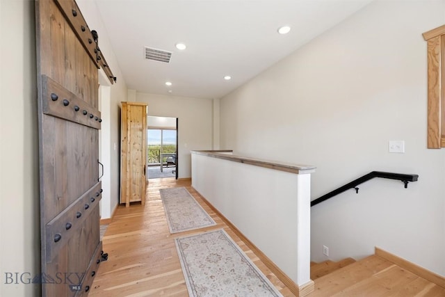 915 Point Of Rocks Rd, Whitehall, MT 59759 - corridor with a barn door, an upstairs landing, light wood-type flooring, and recessed lighting
