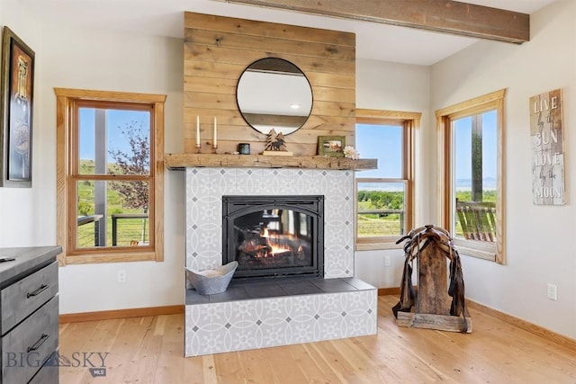 915 Point Of Rocks Rd, Whitehall, MT 59759 - living area with wood finished floors, a tiled fireplace, and beam ceiling