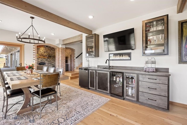 915 Point Of Rocks Rd, Whitehall, MT 59759 - dining area featuring wine cooler, bar with sink, beamed ceiling, light wood-type flooring, and a chandelier