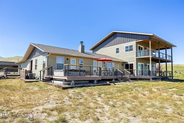915 Point Of Rocks Rd, Whitehall, MT 59759 - back of property featuring board and batten siding, a balcony, a lawn, a wooden deck, and a chimney