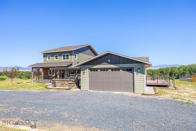 915 Point Of Rocks Rd, Whitehall, MT 59759 - view of front of home with a mountain view, a porch, board and batten siding, an attached garage, and gravel driveway