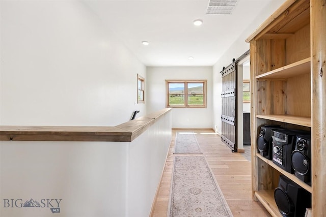 915 Point Of Rocks Rd, Whitehall, MT 59759 - hallway featuring light wood-style flooring, a barn door, and recessed lighting