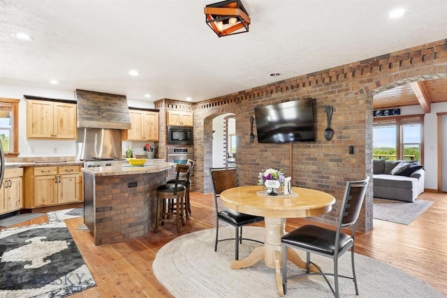 915 Point Of Rocks Rd, Whitehall, MT 59759 - dining space with arched walkways, light wood finished floors, recessed lighting, and brick wall