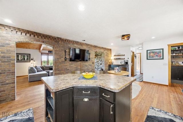915 Point Of Rocks Rd, Whitehall, MT 59759 - kitchen featuring open floor plan, open shelves, light countertops, arched walkways, and brick wall