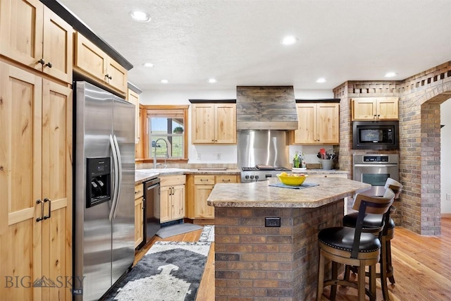 915 Point Of Rocks Rd, Whitehall, MT 59759 - kitchen featuring stainless steel appliances, premium range hood, light brown cabinets, light wood-style floors, and recessed lighting