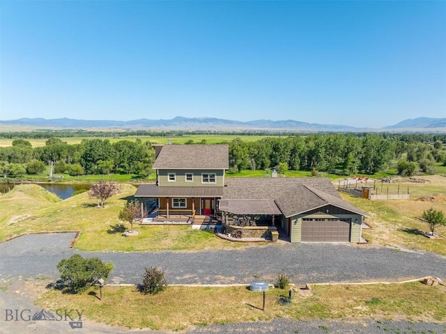 915 Point Of Rocks Rd, Whitehall, MT 59759 - view of front of house featuring covered porch, gravel driveway, an attached garage, and a water view