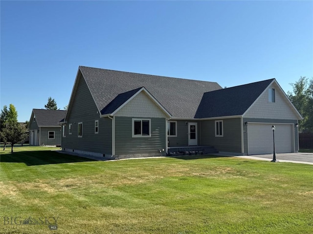 129 E Tobiano Trl, Belgrade, MT 59714 - view of front facade with an attached garage, driveway, a front yard, and a shingled roof