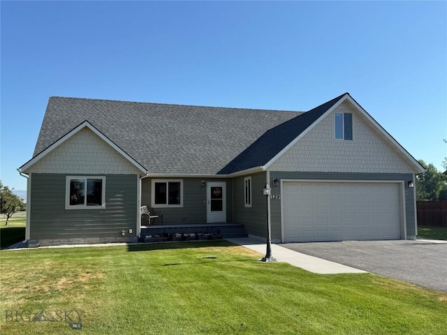 129 E Tobiano Trl, Belgrade, MT 59714 - view of front of home with driveway, a front yard, roof with shingles, and a garage