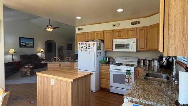 129 E Tobiano Trl, Belgrade, MT 59714 - kitchen with white appliances, wooden counters, open floor plan, arched walkways, and dark wood-style flooring