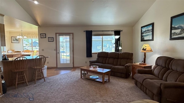 129 E Tobiano Trl, Belgrade, MT 59714 - living area with vaulted ceiling, a chandelier, light colored carpet, and light wood-style floors