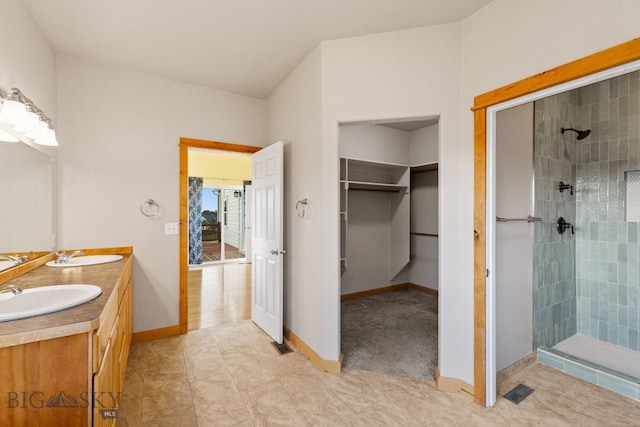 74 W Clara Ct, Bozeman, MT 59718 - full bathroom with tiled shower, double vanity, a spacious closet, and tile patterned flooring