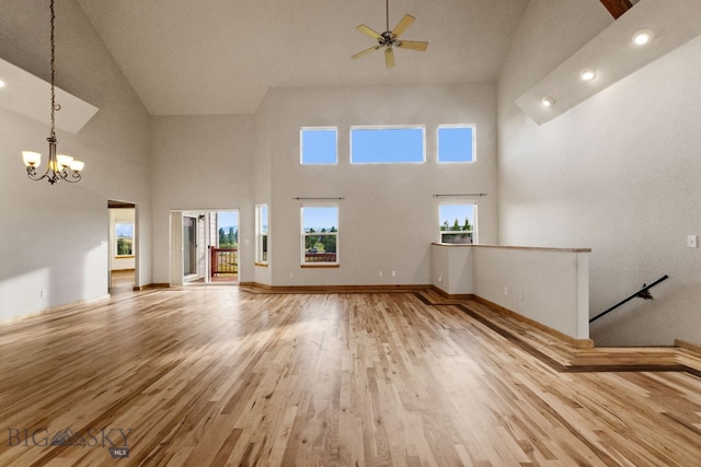 74 W Clara Ct, Bozeman, MT 59718 - unfurnished living room featuring high vaulted ceiling, a chandelier, wood finished floors, and a ceiling fan
